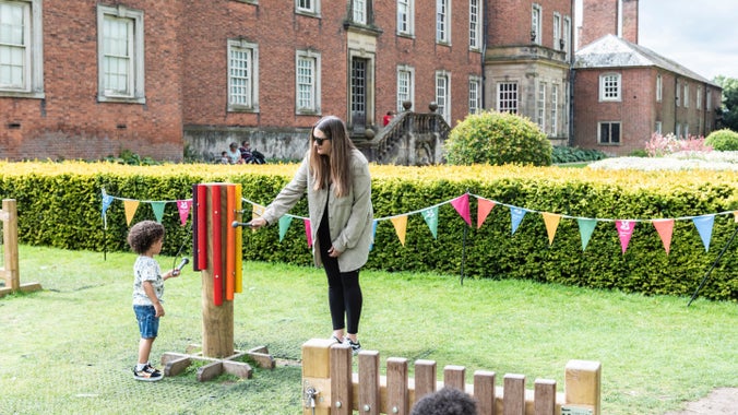 A family playing with giant musical instruments at Dunham Massey, Cheshire.